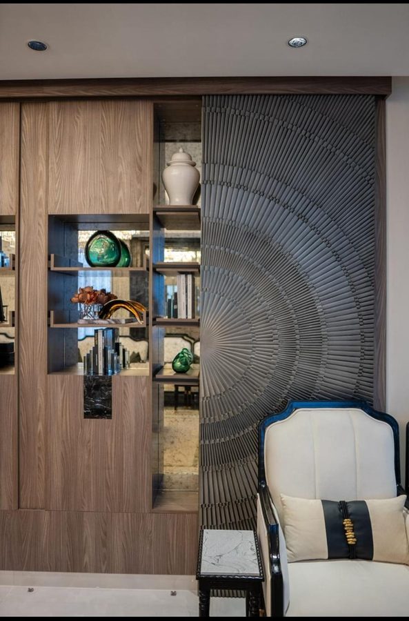 Walnut display unit beside a carved armchair