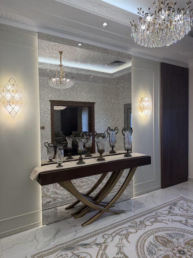 Entrance console beneath a crystal chandelier