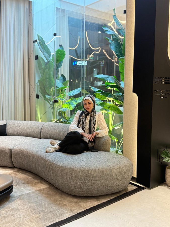 Farah on a curved sofa in the showroom