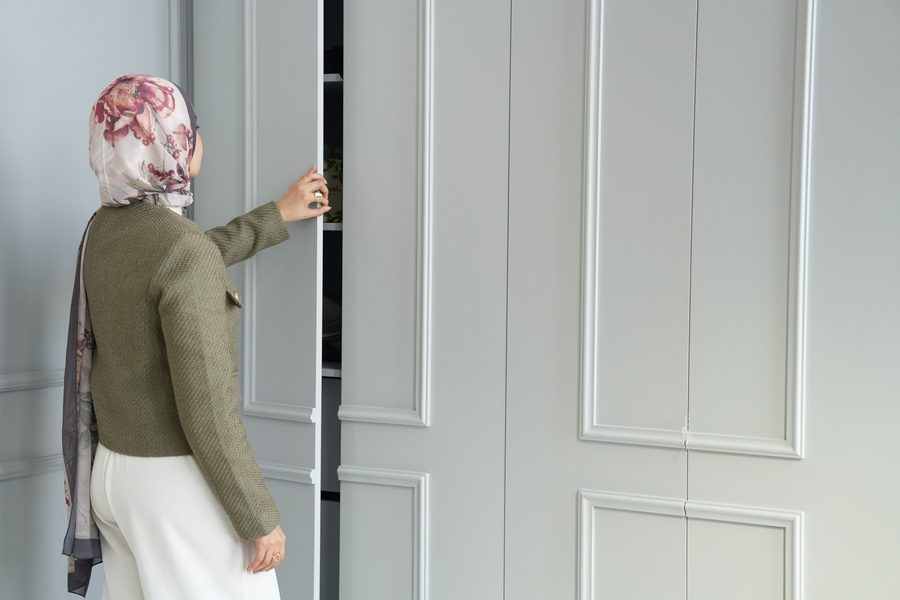 Farah opening a panelled wardrobe door