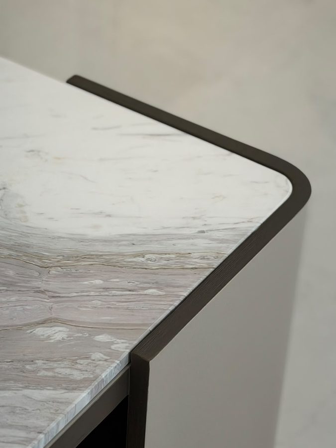 Marble table top with a curved bronze-edged frame