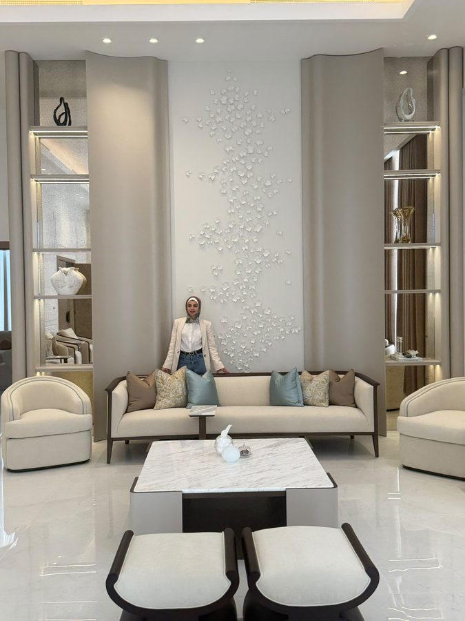 Farah in the finished living room, in front of a sculpted feature wall