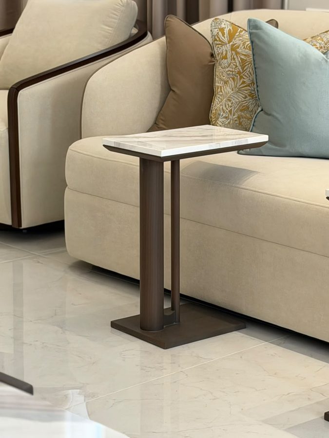 Sofa with a walnut side table and blue-and-gold cushions