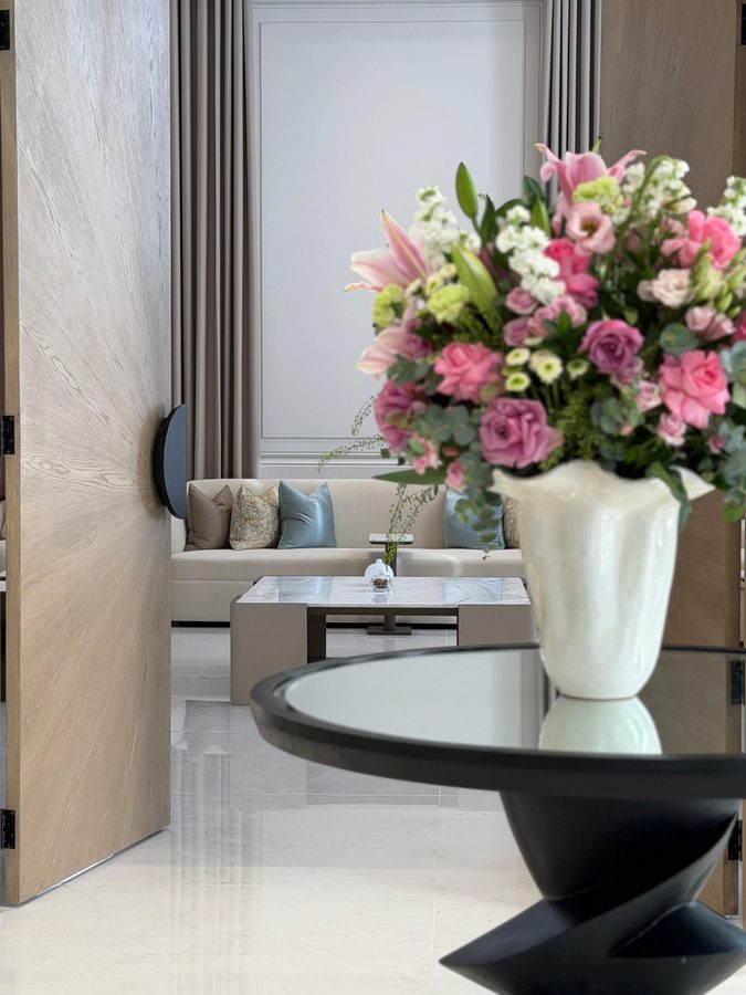 Flowers on a black sculpted table, the majlis beyond