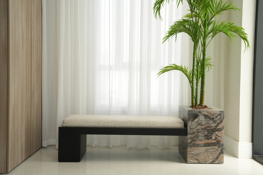 Entrance bench with a marble planter and palm