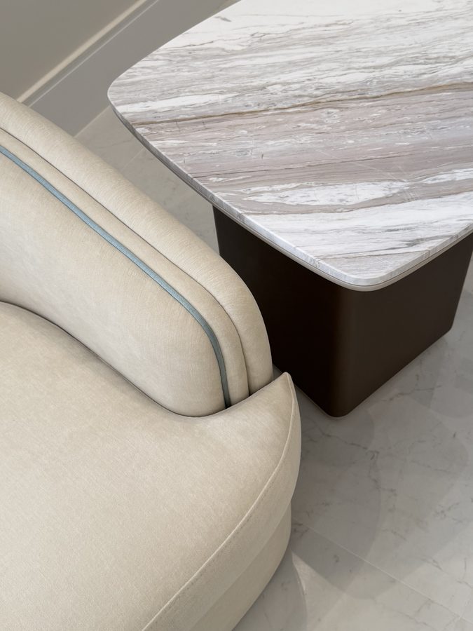 Curved sofa arm against a marble table top