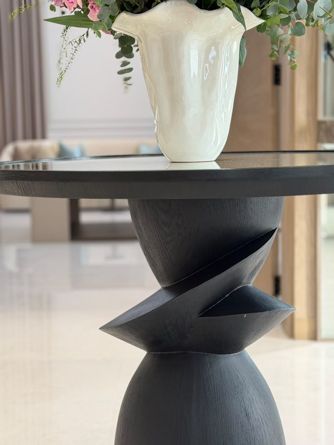 Sculpted black table with a white vase